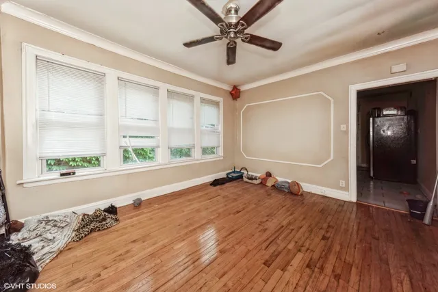 a view of a livingroom with wooden floor and a ceiling fan