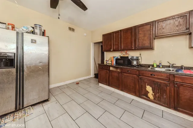 a kitchen with stainless steel appliances granite countertop a refrigerator a sink and wooden cabinets