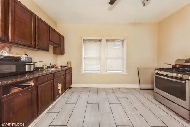 a kitchen with stainless steel appliances granite countertop a stove a sink and a microwave