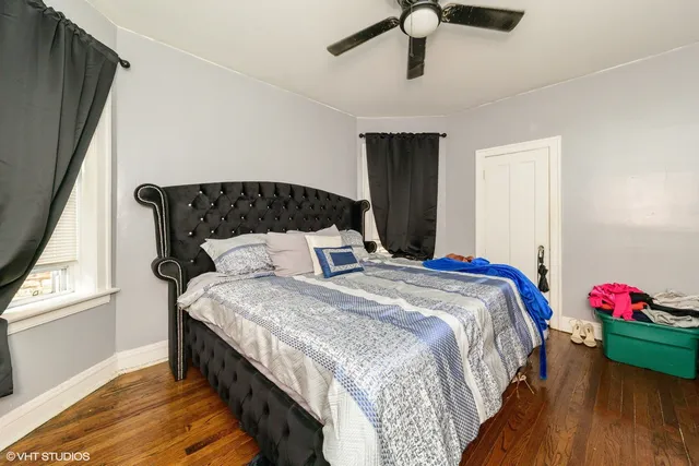 a bedroom with bed and wooden floor