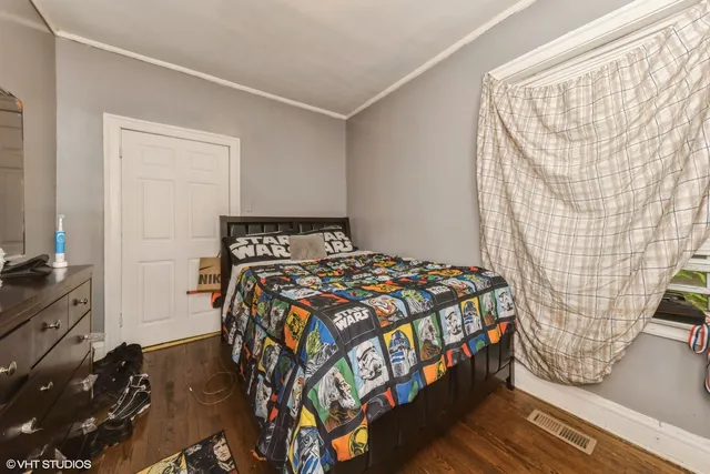 a bedroom with a bed and a flat tv screen on the dresser