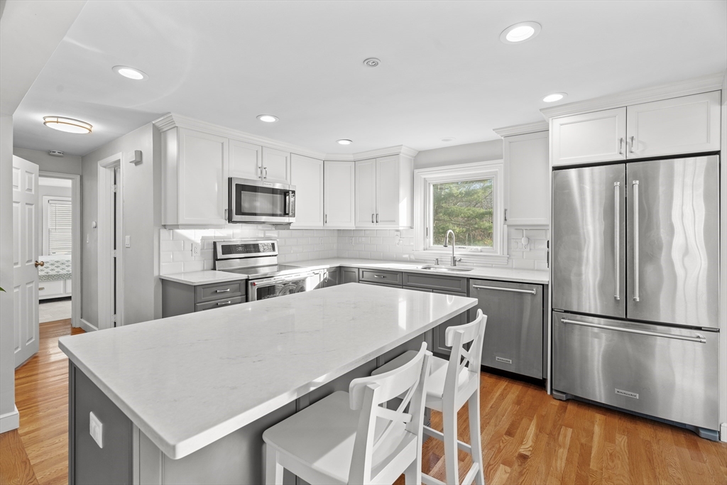 21 Oakvale Road Framingham, MA 01701 - Photo 8 of 42 a kitchen with kitchen island a refrigerator stove microwave and cabinets