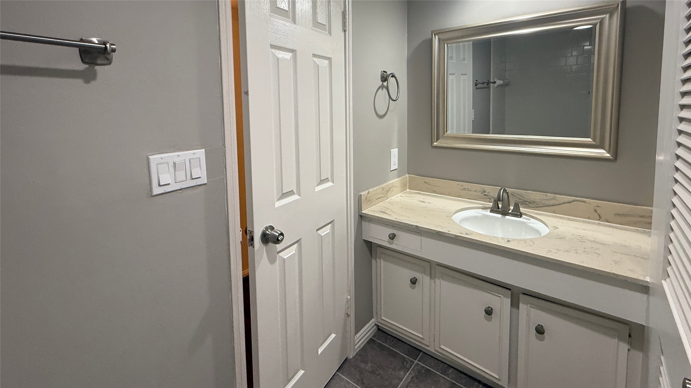 624 South Ripple Creek Drive, Unit 624 Houston, TX 77057 - Photo 18 of 30 a bathroom with a granite countertop sink and a mirror