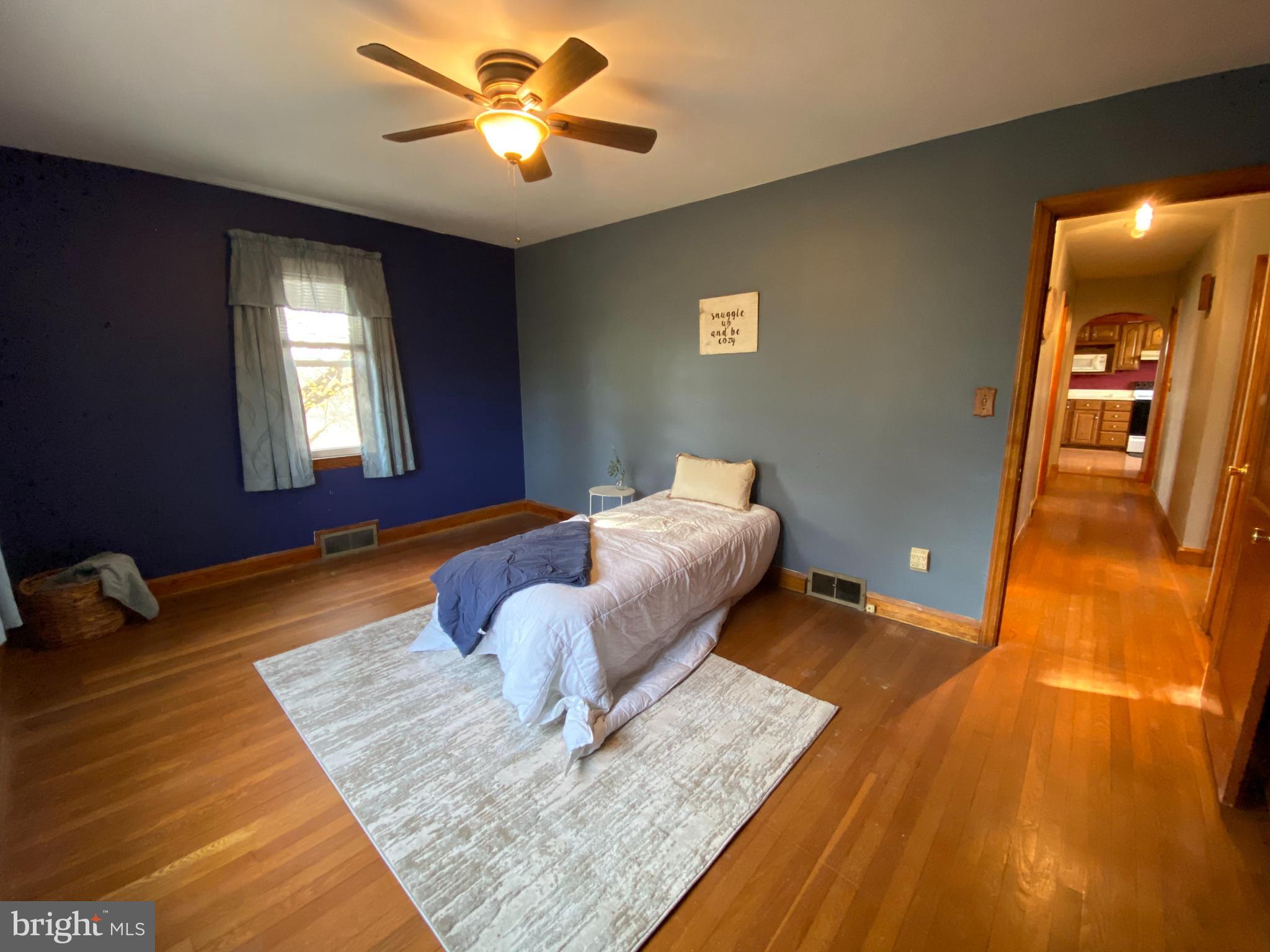 1026 Green Valley Road New Windsor, MD 21776 - Photo 13 of 57 a living room with a bed furniture and a wooden floor