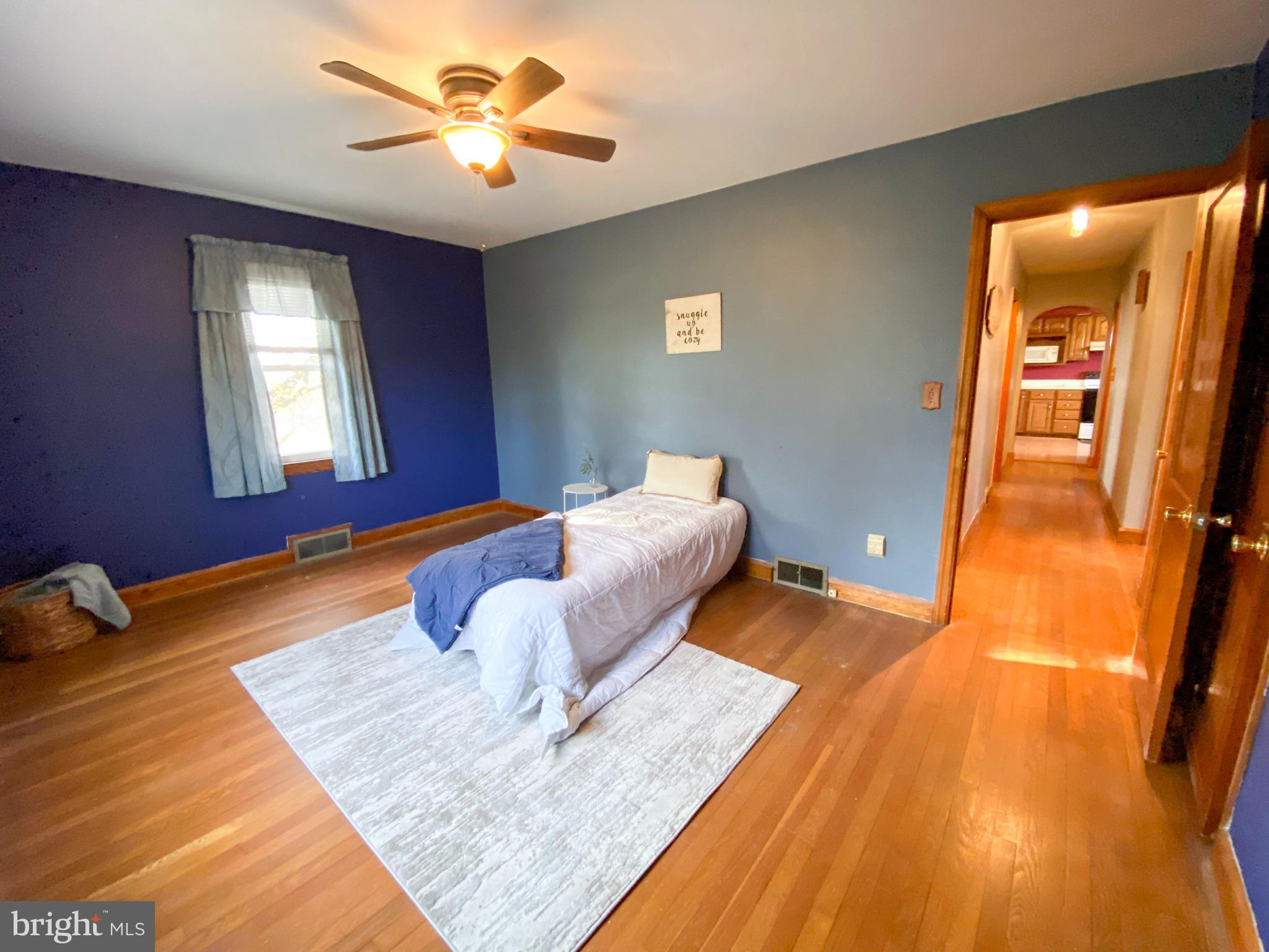 1026 Green Valley Road New Windsor, MD 21776 - Photo 35 of 57 a bedroom with a bed and wooden floor