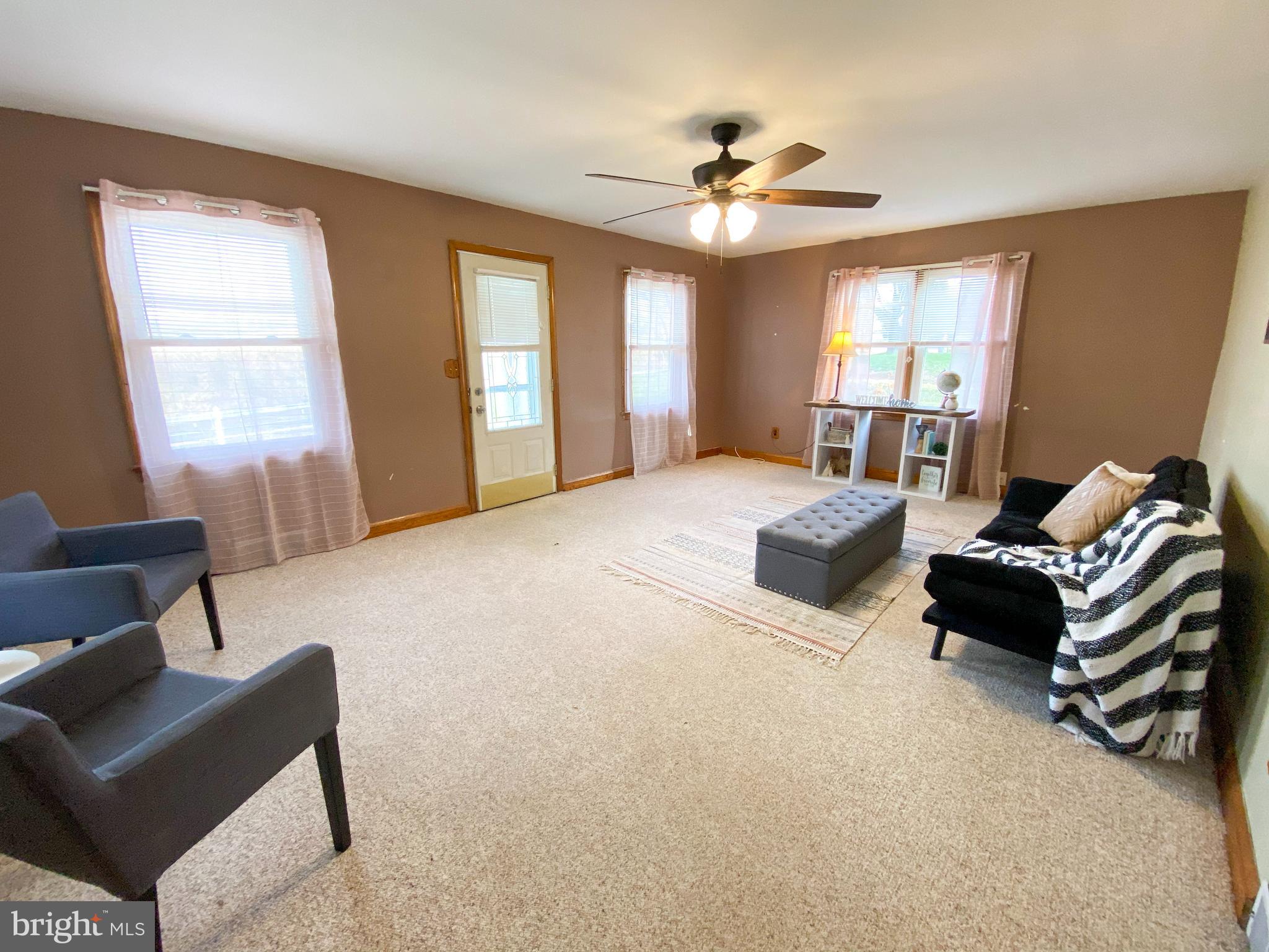 1026 Green Valley Road New Windsor, MD 21776 - Photo 8 of 57 a spacious bedroom with a bed a couch and a chandelier