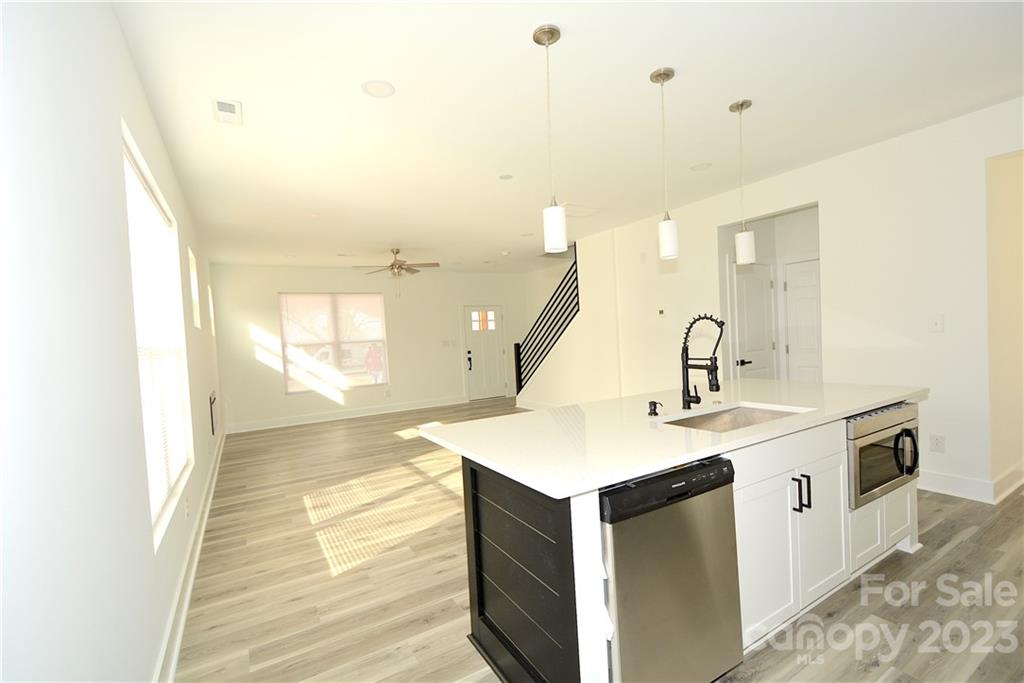 1511 Farm Road Shelby, NC 28152 - Photo 7 of 36 a kitchen with a sink dishwasher and white cabinets with wooden floor