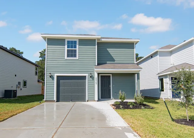 a front view of a house with a garden and garage