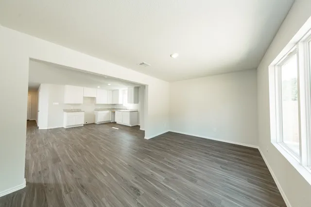 a view of empty room with wooden floor and window