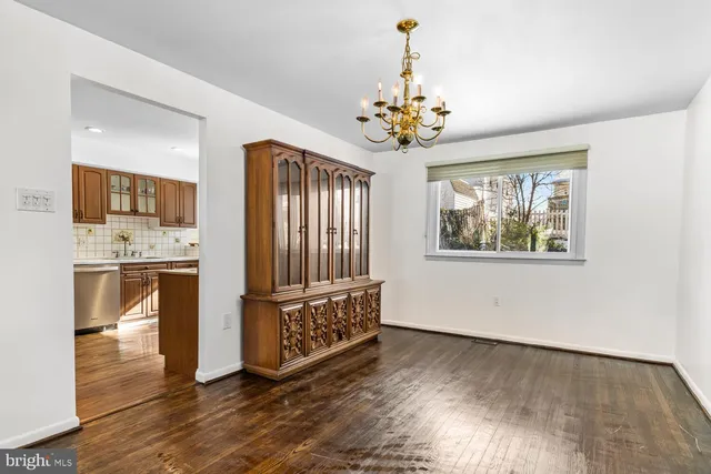 a view of a hallway with wooden floor and a kitchen