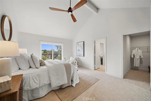 a bedroom with a bed a chandelier and a window