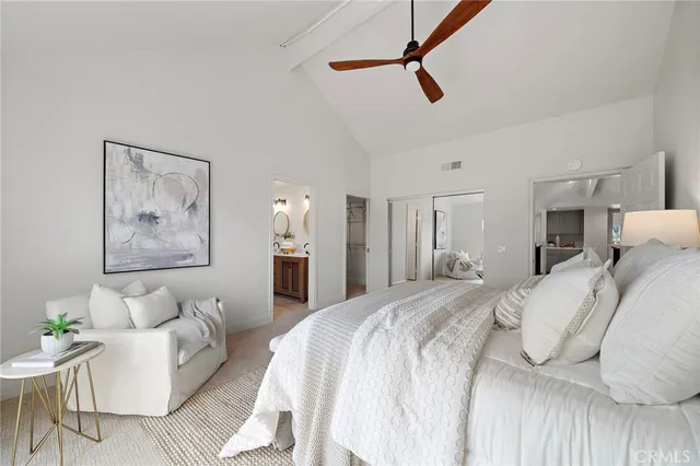 a spacious bedroom with a bed a couch and a view of bathroom