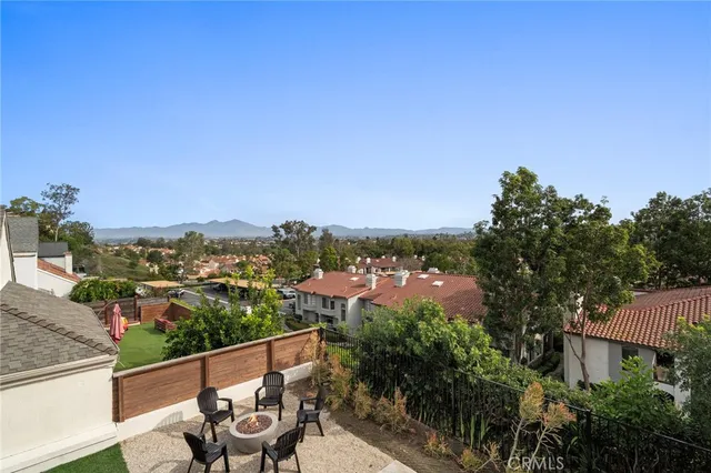 a view of a city from a balcony with outdoor seating