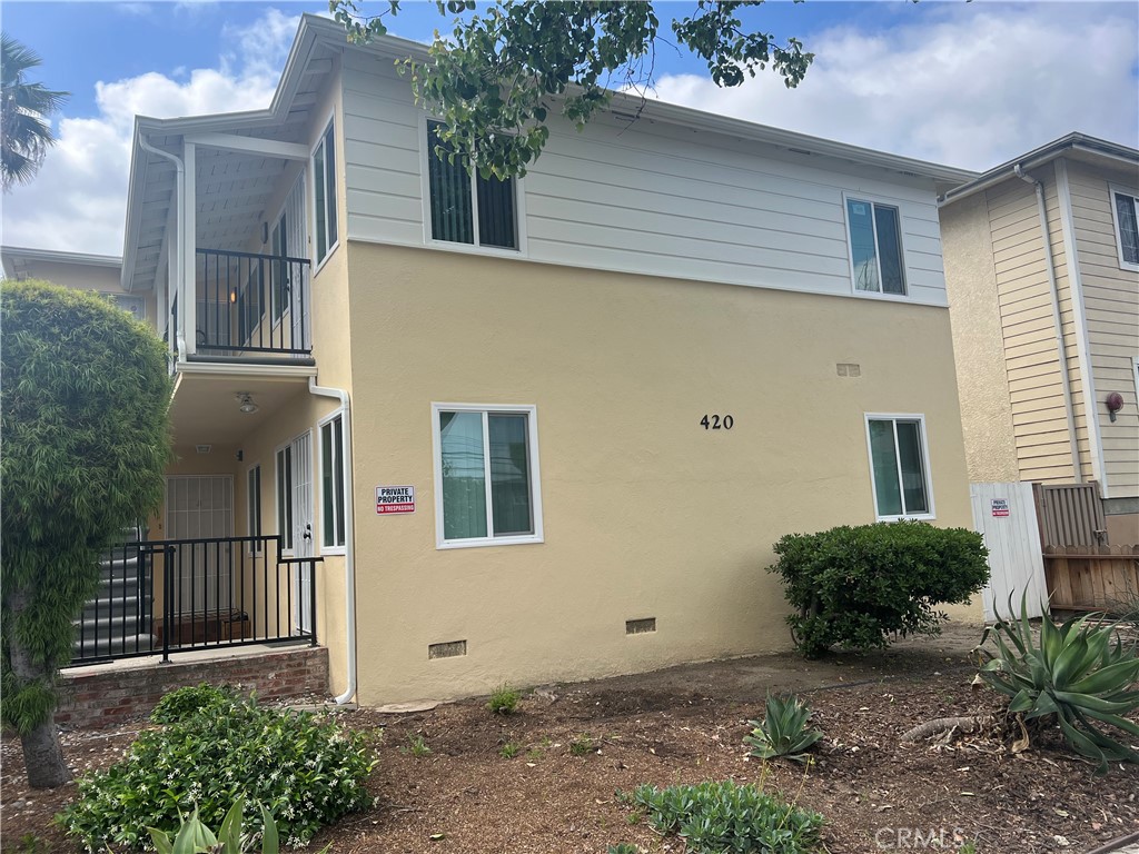 a view of a house with a yard and potted plants