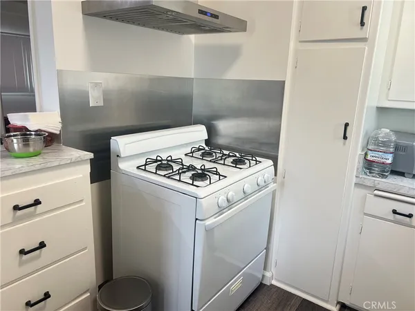 a white stove top oven sitting inside of a kitchen