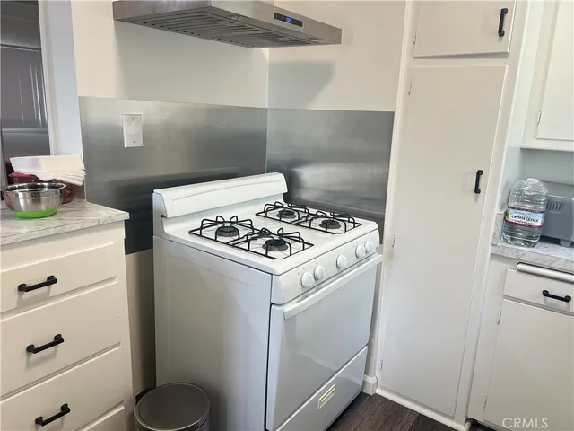a white stove top oven sitting inside of a kitchen