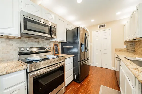 a kitchen with stainless steel appliances and wooden cabinets