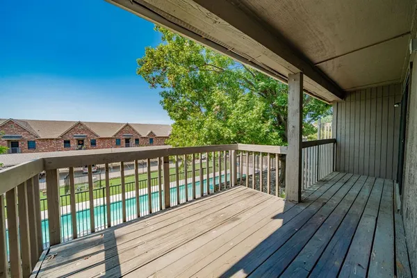 a view of a wooden balcony with furniture