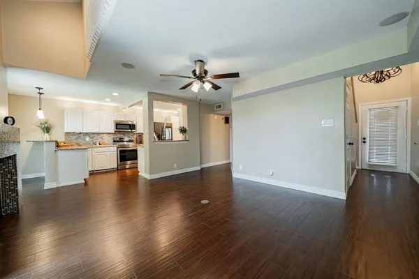 a view of a kitchen with a sink a refrigerator and wooden floor
