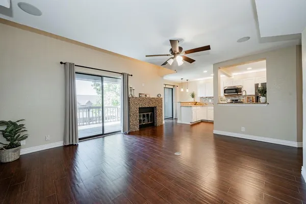 a view of a kitchen with furniture a ceiling fan and wooden floor