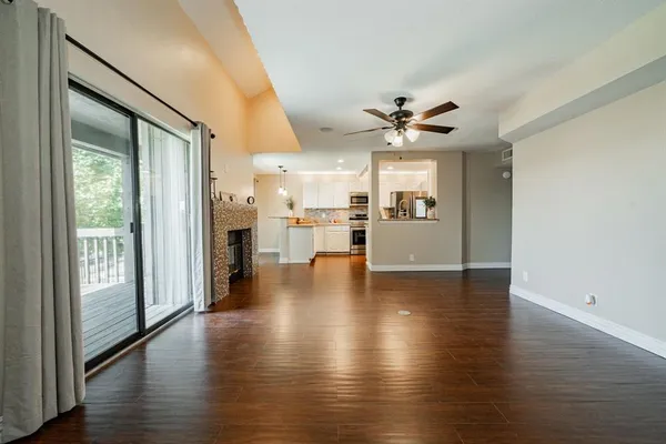 a view of a kitchen with a kitchen island wooden floor and a ceiling fan