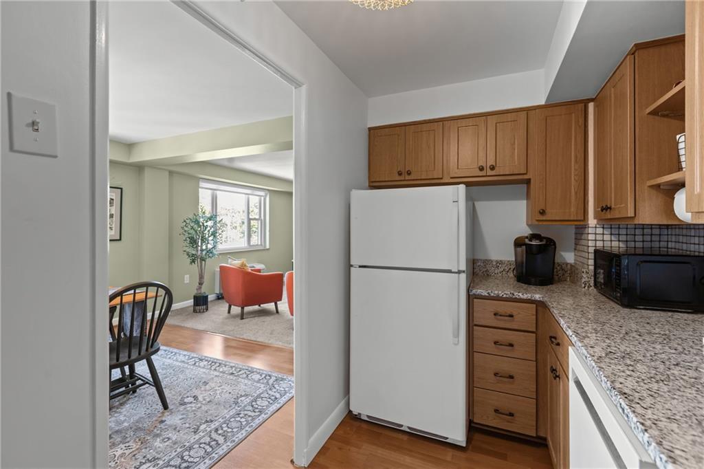 4625 Fifth Avenue, Unit 206 Pittsburgh, PA 15213 - Photo 18 of 31 a kitchen with stainless steel appliances granite countertop a refrigerator a stove a sink a dining table and chairs