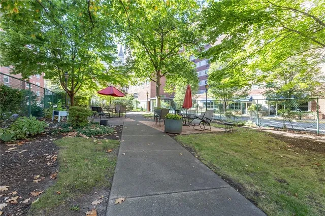 a street view with a building and trees in the background