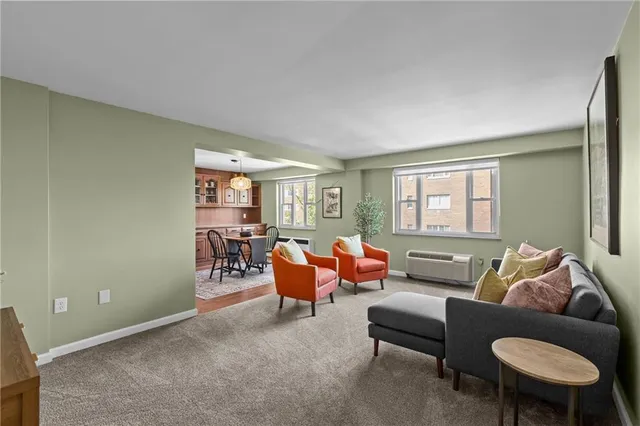 a living room with furniture a rug and a window