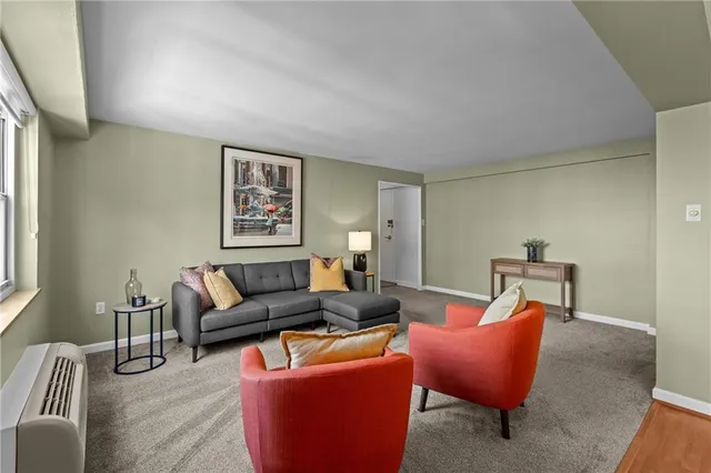 a living room with furniture a lamp and a potted plant