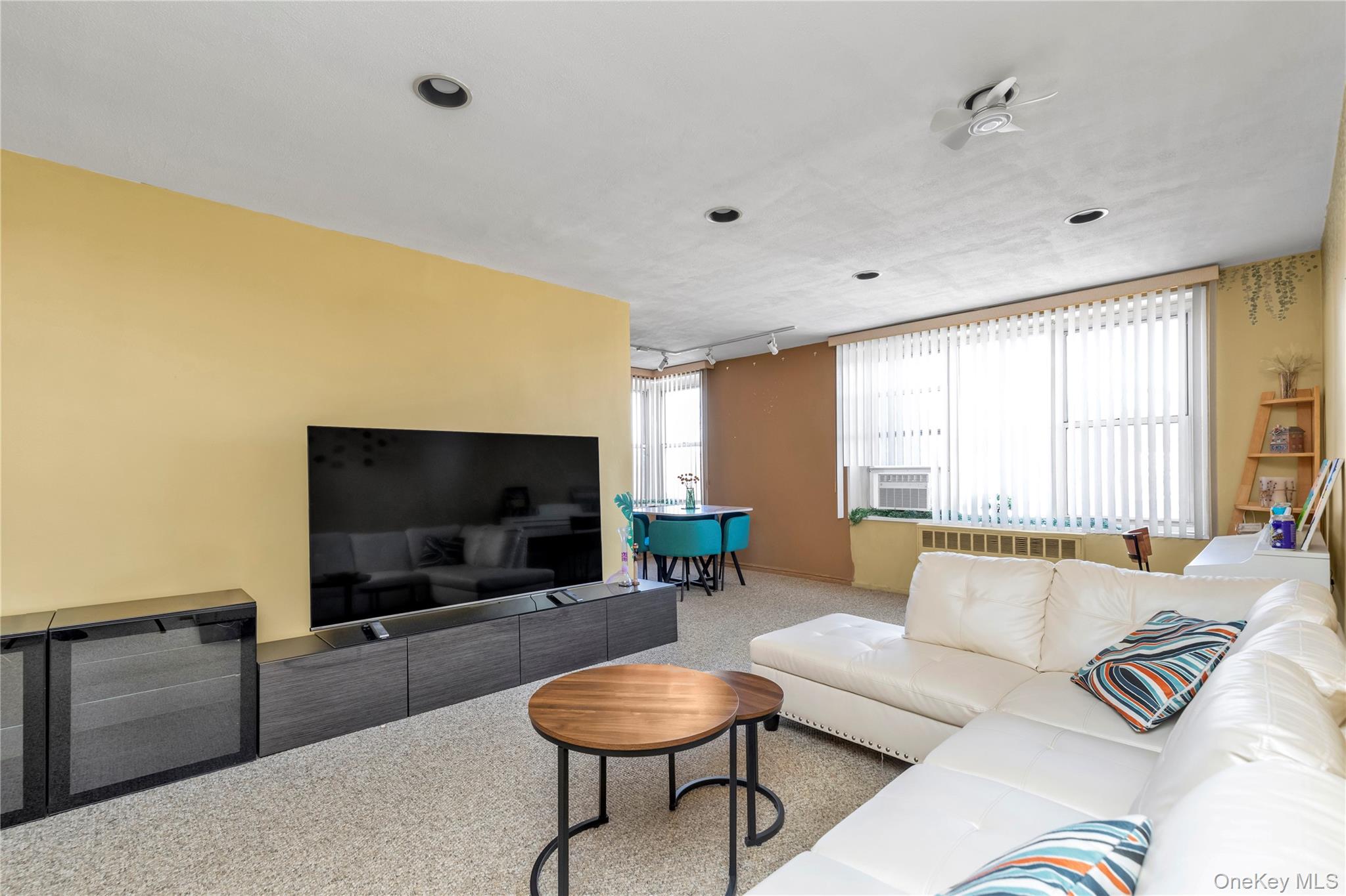 209-20 18th Avenue, Unit 6C Queens, NY 11360 - Photo 6 of 14 a living room with furniture and a flat screen tv