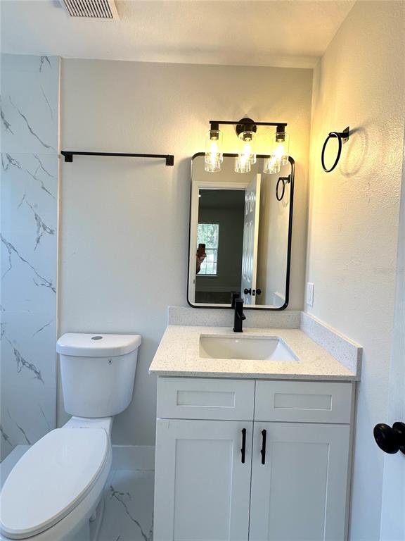 1758 Clarcona Road Apopka, FL 32703 - Photo 11 of 20 a bathroom with a toilet sink and mirror