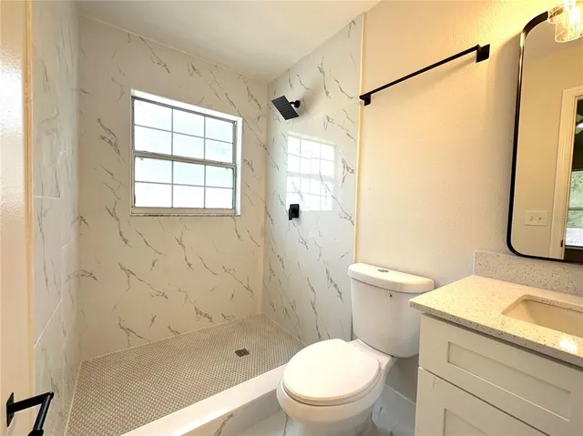 a white toilet sitting next to a bath tub shower