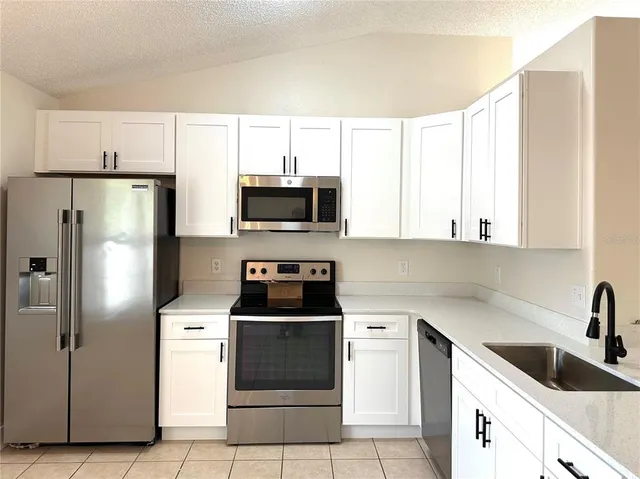 a kitchen with stainless steel appliances a refrigerator sink and microwave