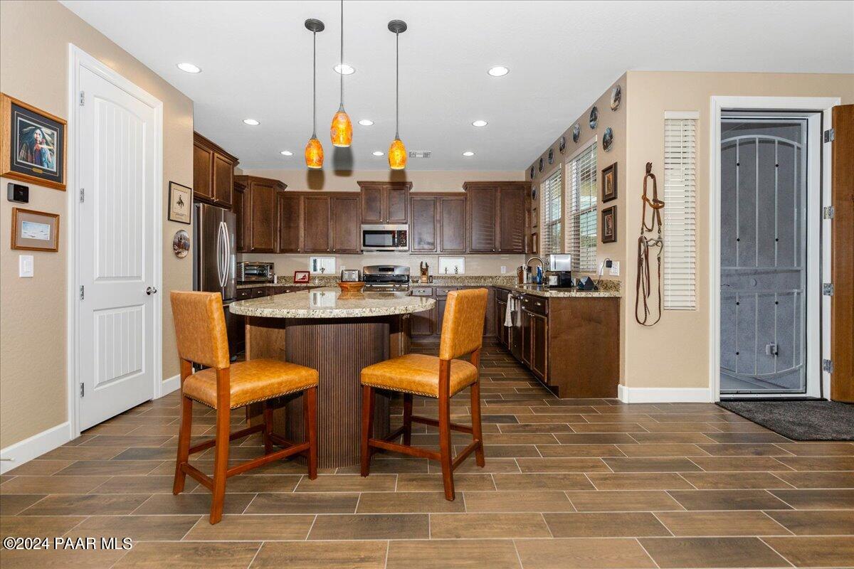 2206 Calgary Drive Prescott, AZ 86301 - Photo 10 of 54 a kitchen with stainless steel appliances granite countertop a sink a stove a refrigerator cabinets and chairs