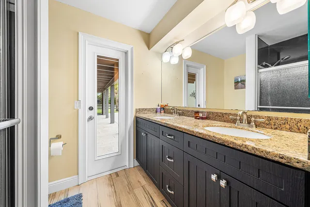 a bathroom with a granite countertop sink and a mirror