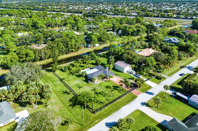 an aerial view of residential houses with outdoor space and trees