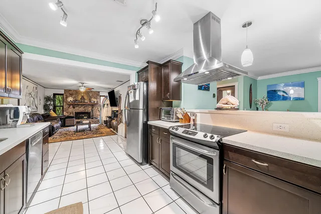 a kitchen with stainless steel appliances granite countertop a sink a stove and a refrigerator