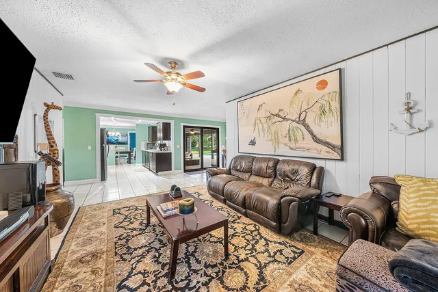 a living room with furniture ceiling fan and a rug
