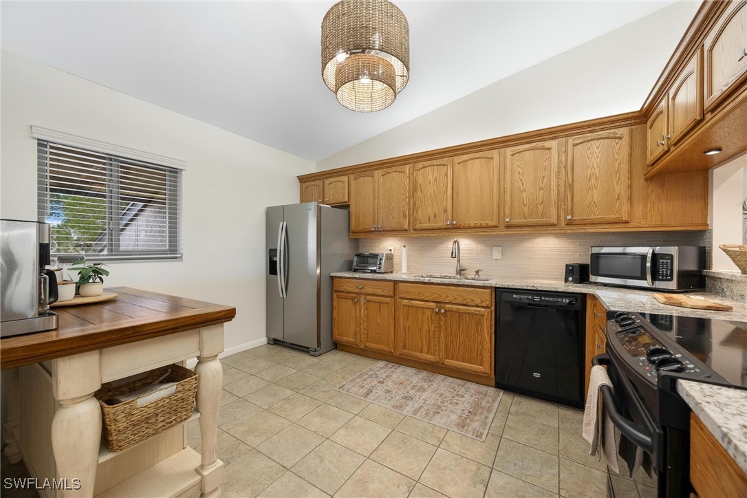 16650 Partridge Place Road, Unit 204 Fort Myers, FL 33908 - Photo 11 of 47 a kitchen with granite countertop a stove cabinets and refrigerator
