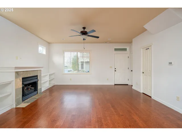 a view of an empty room with a fireplace and a window