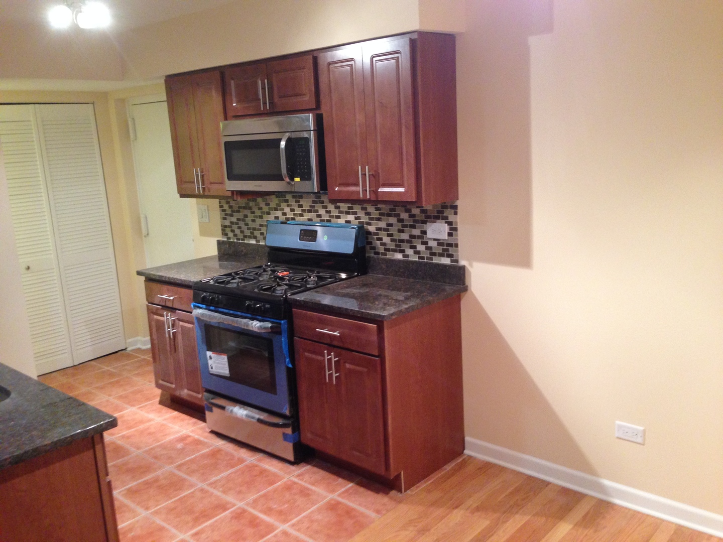 672 Cleo Court Wheeling, IL 60090 - Photo 6 of 20 a kitchen with granite countertop a stove and a microwave with cabinets