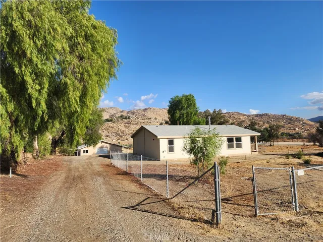 a view of a patio with table and chairs with wooden fence