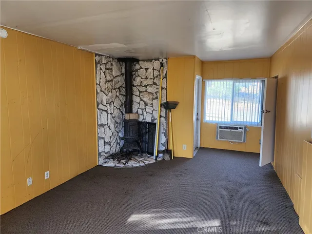 a view of an empty room with window and cabinet