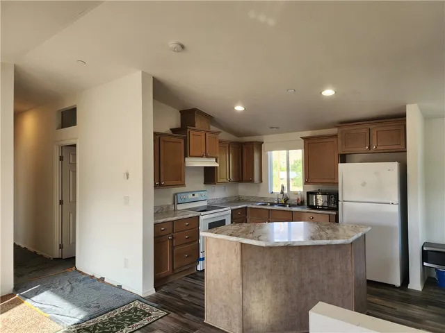 a kitchen with kitchen island a sink stove and refrigerator
