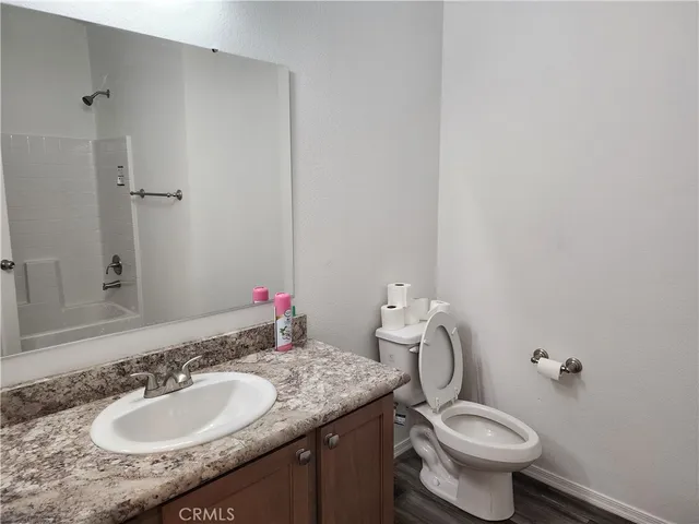 a bathroom with a granite countertop sink toilet and a mirror