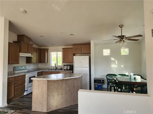 a kitchen with kitchen island a sink a counter top space and stainless steel appliances