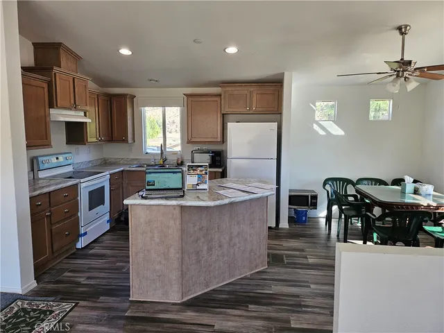 a kitchen with kitchen island a stove a counter space and a dining table