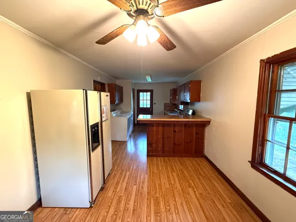 a kitchen with stainless steel appliances a refrigerator stove and wooden floor