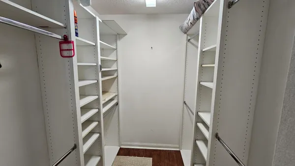 a view of walk in closet with empty racks