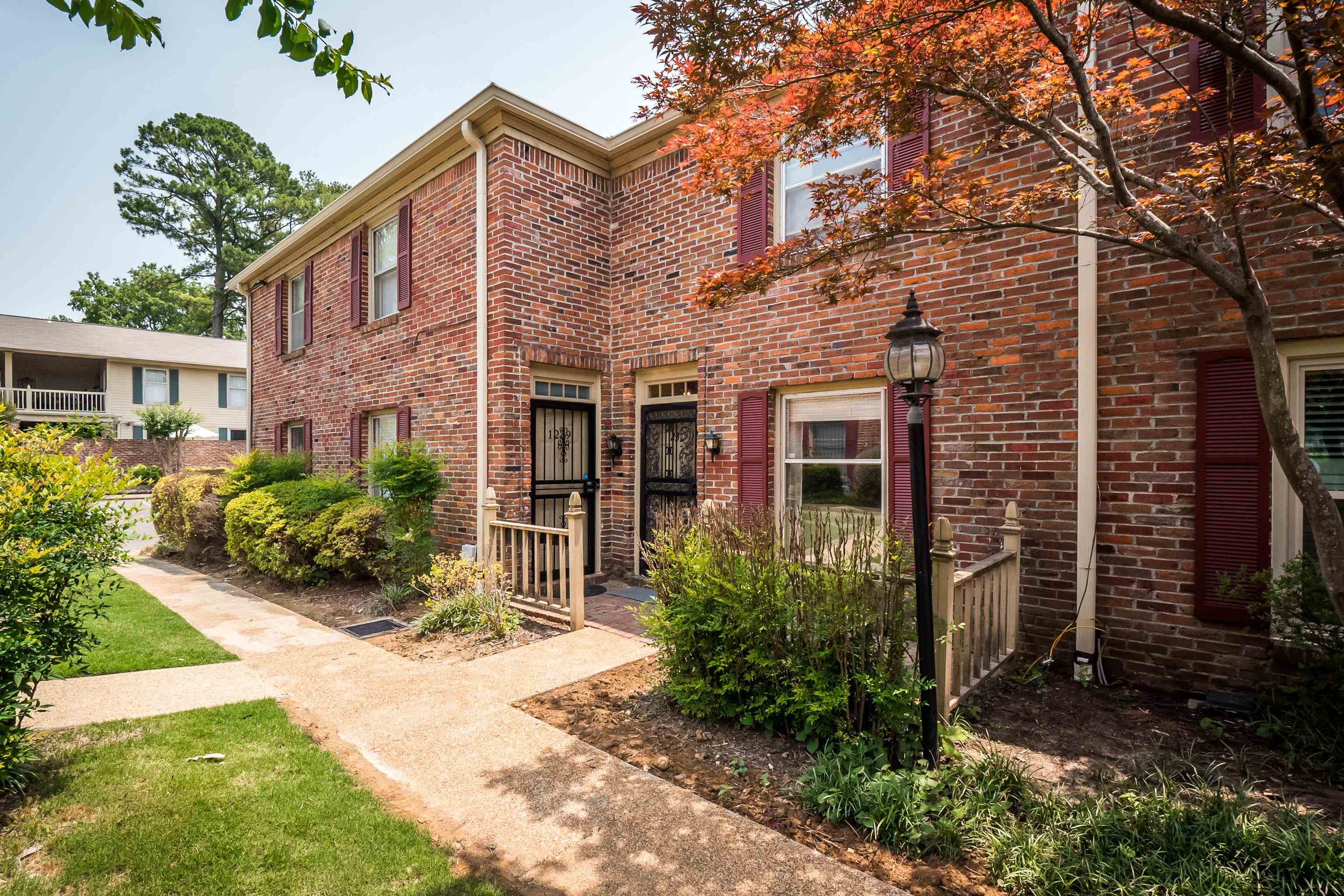 1237 Chamberlain Drive, Unit 1237 Memphis, TN 38119 - Photo 1 of 25 a view of a brick house with many windows plants and large tree